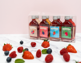 Gift pack of eight 50ml Hogg Norton fruit liqueur bottles with mixed berry, blackberry, strawberry, and raspberry flavors, surrounded by fresh berries on a marble surface. Gluten Free, Vegan friendly, no additives or preservatives. hoggnorton, Liqueurs